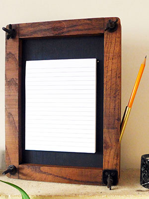 Tennis racket frame repurposed as a list holder
